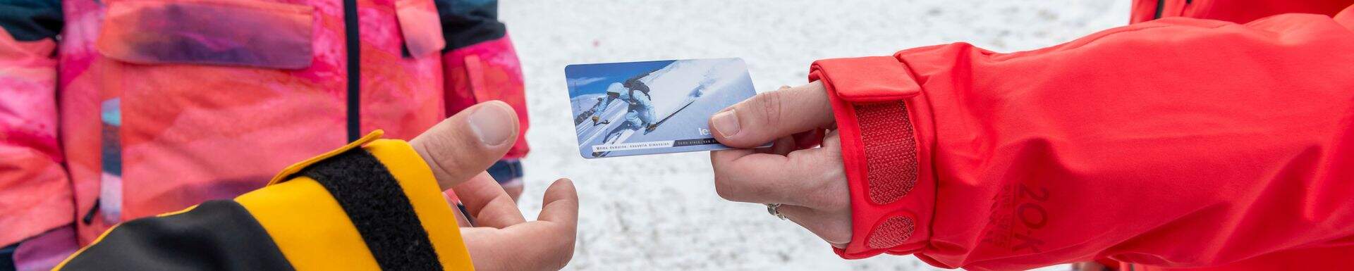 Sunweb ski guide giving a liftpass to a guest